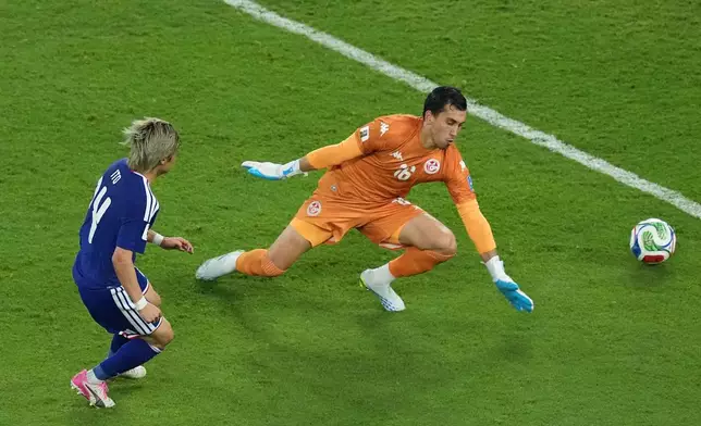 Junya Ito scores Japan's third goal past Tunisia goalkeeper Aymen Dahmen during a World Cup Group F soccer match in Guadalupe, near Monterrey, Mexico, Saturday, June 20, 2026. (AP Photo/Moises Castillo)