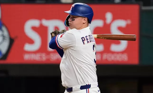 Texas Rangers' Joc Pederson follows through on a single in the eighth inning of a baseball game against the Minnesota Twins in Arlington, Texas, Monday, June 15, 2026. (AP Photo/Tony Gutierrez)