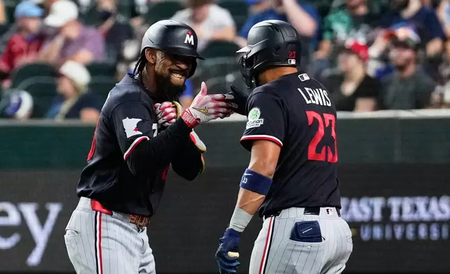 Minnesota Twins' Byron Buxton, left, and Royce Lewis (23) celebrates Buxton's solo home run in the sixth inning of a baseball game against the Texas Rangers in Arlington, Texas, Monday, June 15, 2026. (AP Photo/Tony Gutierrez)