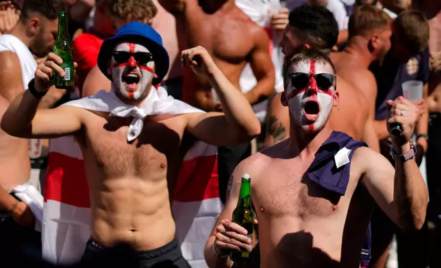 FILE - Men with face painted in the colors on the England flag chant slogans and drink beers at Breitscheidplatz before the start of the final match between Spain and England at the Euro 2024 soccer tournament in Berlin, Germany, July 14, 2024. (AP Photo/Ariel Schalit, File)
