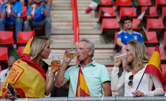 FILE - Fans have a drink on the stands while waiting for the start of the Nations League semifinal soccer match between Spain and Italy at De Grolsch Veste stadium in Enschede, eastern Netherlands, June 15, 2023. (AP Photo/Peter Dejong, File)