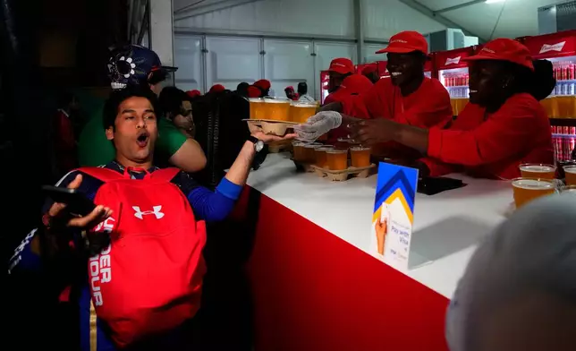 FILE - A man buys beers at a fan zone ahead of the FIFA World Cup, in Doha, Qatar, Nov. 19, 2022. (AP Photo/Petr Josek, File)