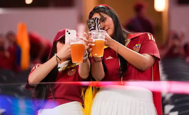 FILE - Venezuela fans take photos of their beers before a Copa America quarterfinal soccer match between Venezuela and Canada, July 5, 2024, in Arlington, Texas. (AP Photo/Julio Cortez, File)
