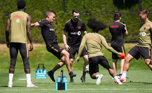Canada head coach Jesse Marsch, back left, kicks a ball during a FIFA World Cup soccer training session, in Vancouver, British Columbia, Tuesday, June 16, 2026. (Darryl Dyck/The Canadian Press via AP)