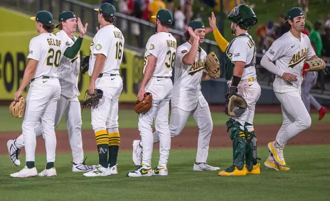 The Athletics celebrate after winning a baseball game against the Los Angeles Angels in West Sacramento, Calif., Thursday, June 18, 2026. (AP Photo/Nic Coury)