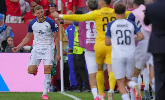 Bosnia's Jovo Lukic, left, celebrates after he scores the opening goal during the World Cup Group B soccer match between Canada and Bosnia in Toronto, Friday, June 12, 2026. (AP Photo/Stephanie Scarbrough)
