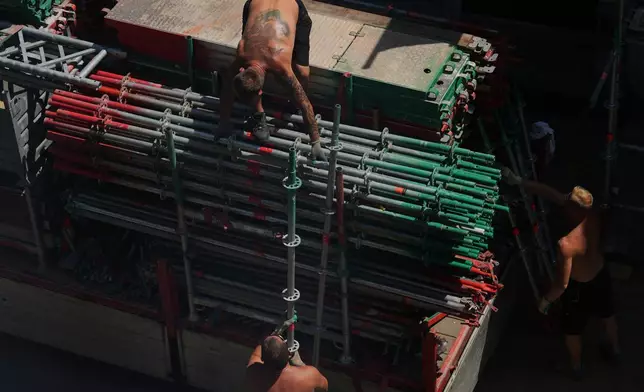 Workers remove scaffolding during a period of high temperatures in Antwerp, Belgium, Wednesday, June 24, 2026. (AP Photo/Virginia Mayo)