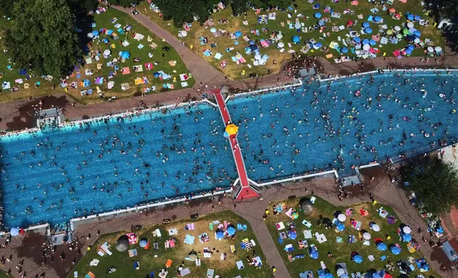 Hundreds of people gather in a public pool in Frankfurt, Germany, on a hot Saturday, June 27, 2026. (AP Photo/Michael Probst)