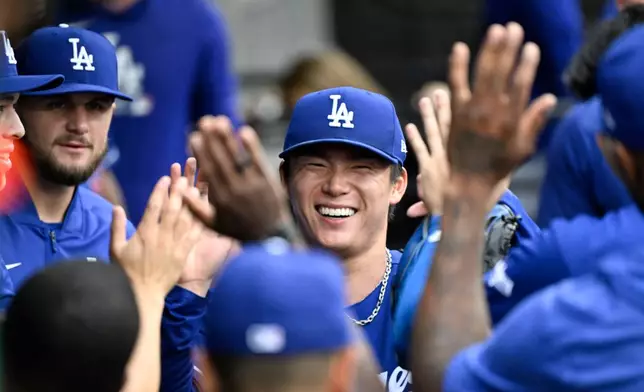 Los Angeles Dodgers pitcher Yoshinobu Yamamoto of Japan, is high-fived by teammates after he was relieved during the ninth inning of a baseball game against theChicago White Sox, Saturday, June 13, 2026, in Chicago. (AP Photo/Matt Marton)