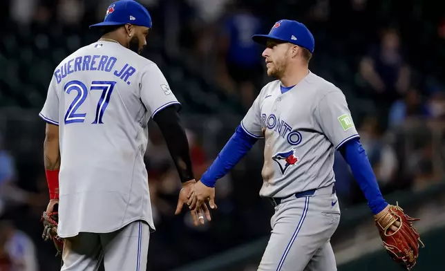 Toronto Blue Jays' Vladimir Guerrero Jr., left, celebrates with Myles Straw, right, after the Blue Jays defeated the Atlanta Braves in a baseball game, Thursday, June 4, 2026, in Atlanta. (AP Photo/Erik S. Lesser)