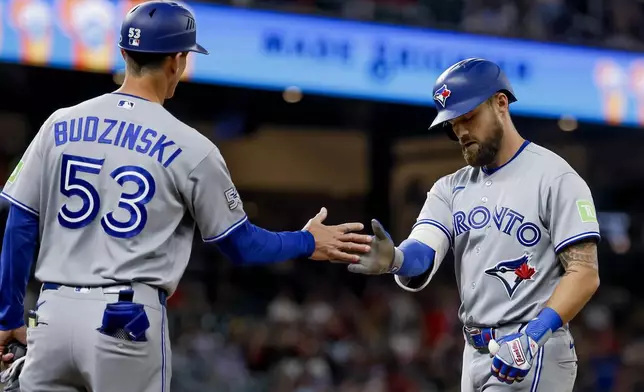 Toronto Blue Jays' Nathan Lukes, right, celebrates with first base coach Mark Budzinski (53) after hitting an RBI single against the Atlanta Braves during the eighth inning of a baseball game, Thursday, June 4, 2026, in Atlanta. (AP Photo/Erik S. Lesser)