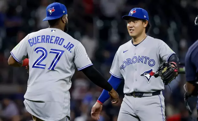 Toronto Blue Jays' Vladimir Guerrero Jr., left, celebrates with Kazuma Okamoto, right, after the Blue Jays defeated the Atlanta Braves in a baseball game, Thursday, June 4, 2026, in Atlanta. (AP Photo/Erik S. Lesser)