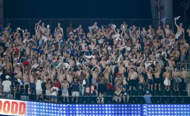 A group of 'tarps off' shirtless male baseball fans cheer from the upper deck of Truist Park as the Atlanta Braves host the Toronto Blue Jays during the eighth inning of a baseball game, Thursday, June 4, 2026, in Atlanta. (AP Photo/Erik S. Lesser)