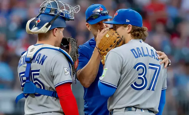 Toronto Blue Jays pitching coach Pete Walker, center, speaks with pitcher Chad Dallas (37) and catcher Tyler Heineman (55) during the third inning of a baseball game against the Atlanta Braves, Thursday, June 4, 2026, in Atlanta. (AP Photo/Erik S. Lesser)