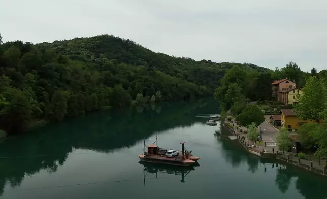 Commuters board the “Da Vinci Ferry,” a hand-operated ferry based on a design sketched by Leonardo da Vinci in the 15th century, on the Adda River between the provinces of Lecco and Bergamo, in Imbersago, Italy, Thursday, June 4, 2026. (AP Photo/Luca Bruno)