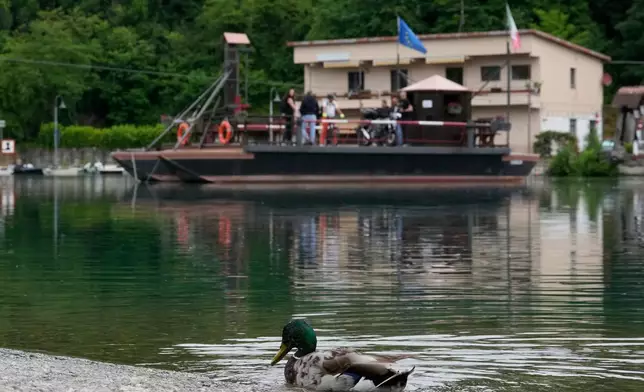 Commuters board the “Da Vinci Ferry,” a hand-operated ferry based on a design sketched by Leonardo da Vinci in the 15th century, on the Adda River between the provinces of Lecco and Bergamo, in Imbersago, Italy, Thursday, June 4, 2026. (AP Photo/Luca Bruno)