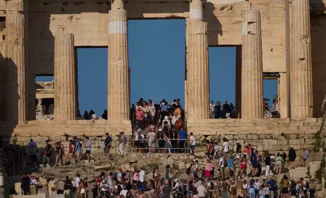 FILE - Tourists visit the 5th century BC Propylaea on the Acropolis Hill during a hot day in Athens, Greece, May 28, 2026.(AP Photo/Petros Giannakouris, File)