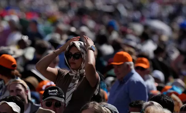 FILE - A faithful protects from the hot sun before Pope Leo XIV's weekly general audience in St. Peter's Square at The Vatican, May 27, 2026. (AP Photo/Alessandra Tarantino, File)