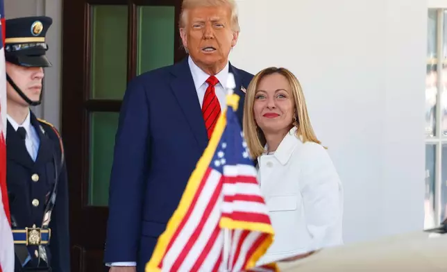 FILE - President Donald Trump, center, greets Italy's Prime Minister Giorgia Meloni, right, upon her arrival at the White House, April 17, 2025, in Washington. (AP Photo/Tom Brenner, File)