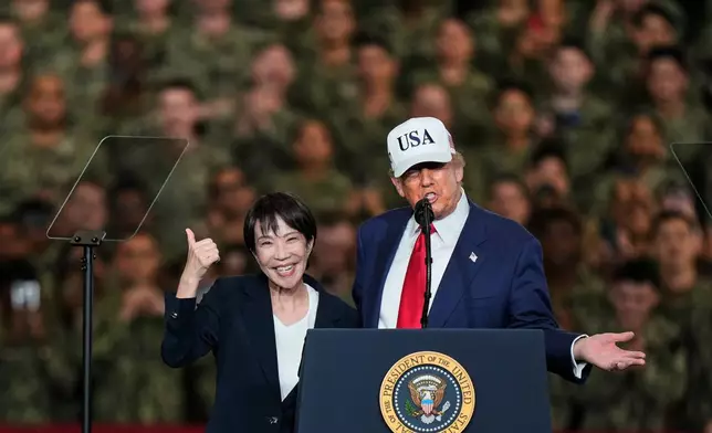 FILE - Japanese Prime Minister Sanae Takaichi gestures as U.S. President Donald Trump delivers his speech during their visit to the aircraft carrier USS George Washington at the U.S. Navy's Yokosuka base in Yokosuka, south of Tokyo, Oct. 28, 2025. (AP Photo/Eugene Hoshiko, File)