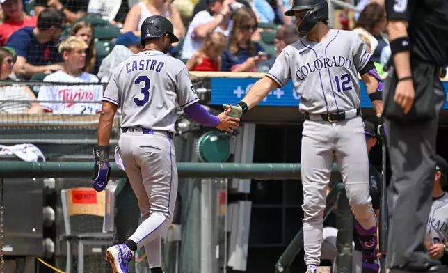 Colorado Rockies' Willi Castro (3) celebrates with Kyle Karros (12) after scoring on a TJ Rumfield single against the Minnesota Twins during the first inning of a baseball game Sunday, June 28, 2026, in Minneapolis. (AP Photo/Craig Lassig)