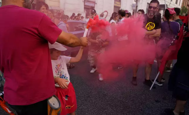 Demonstrators light flares during a march in Rome, Saturday, June 13, 2026, to protest Italy's security and migration package, including a migrant "repatriation bonus" scheme criticized by opposition parties and legal groups as unconstitutional and ethically problematic. (AP Photo/Gregorio Borgia)