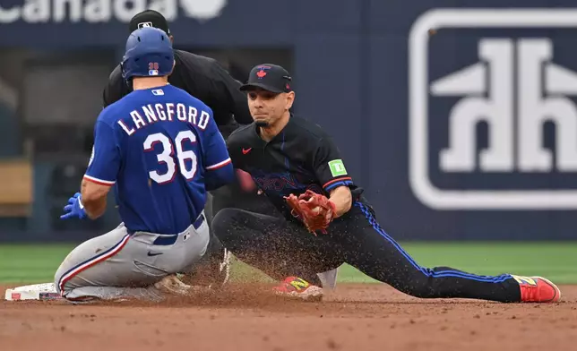 Texas Rangers Wyatt Langford (36) is tagged out at second base by Toronto Blue Jays infielder Andres Gimenez (0) during the second inning of a baseball game in Toronto, Friday June 26, 2026. (Jon Blacker/The Canadian Press via AP)