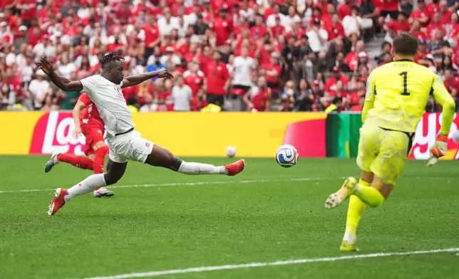 Canada's Promise David (24) scores their first goal past Switzerland goalkeeper Gregor Kobel (1) during the World Cup Group B soccer match between Switzerland and Canada in Vancouver, British Columbia, Wednesday, June 24, 2026. (Darryl Dyck/The Canadian Press via AP)