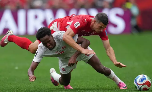 Canada's Ali Ahmed (20) and Switzerland's Remo Freuler (8) battle for the ball during the World Cup Group B soccer match between Switzerland and Canada in Vancouver, British Columbia, Wednesday, June 24, 2026. (AP Photo/Abbie Parr)