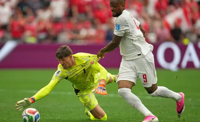 Switzerland goalkeeper Gregor Kobel stops a ball while having his jersey pulled by Canada's Cyle Larin (9) during the World Cup Group B soccer match between Switzerland and Canada in Vancouver, British Columbia, Wednesday, June 24, 2026. (AP Photo/Abbie Parr)