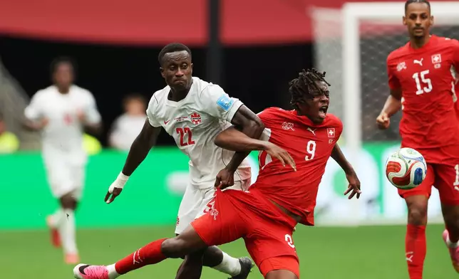 Switzerland's Johan Manzambi (9) cries out as he collides with Canada's Richie Laryea (22) during the World Cup Group B soccer match between Switzerland and Canada in Vancouver, British Columbia, Wednesday, June 24, 2026. (AP Photo/Sydney Shankman)