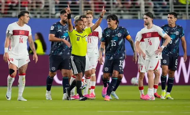 Referee Ivan Arcides Barton Cisneros, of El Salvador, signals to ask for a VAR review before issuing a red card to Paraguay's Miguel Almiron (10) during the World Cup Group D soccer match between Turkey and Paraguay in Santa Clara, Calif., near San Francisco, Friday, June 19, 2026. (AP Photo/Eugene Hoshiko)