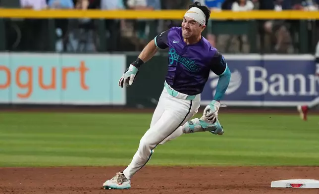 Arizona Diamondbacks' Corbin Carroll rounds secondbase after hitting a three-run triple against the Minnesota Twins in the eighth inning of a baseball game, Friday, June 19, 2026, in Phoenix. (AP Photo/Rick Scuteri)
