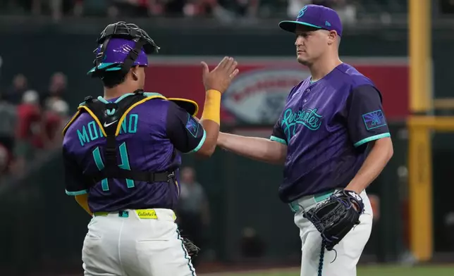 Arizona Diamondbacks catcher Gabriel Moreno (14) and pitcher Paul Sewald celebrate after defeating the Minnesota Twins during a baseball game, Friday, June 19, 2026, in Phoenix. (AP Photo/Rick Scuteri)
