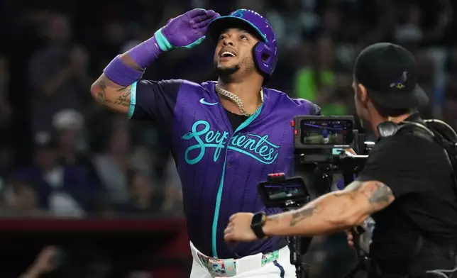 Arizona Diamondbacks' Ketel Marte, left, reacts after hitting a solo home run against the Minnesota Twins in the sixth inning of a baseball game, Friday, June 19, 2026, in Phoenix. (AP Photo/Rick Scuteri)