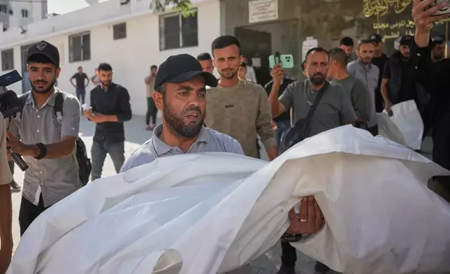 Mourners carry the bodies of two Palestinian girls Zeina Safadi, and her sister Lana, who were killed during an overnight Israeli airstrike that damaged their home, during their funeral in Gaza city, Saturday, June 20, 2026. (AP Photo/Abdel Kareem Hana)