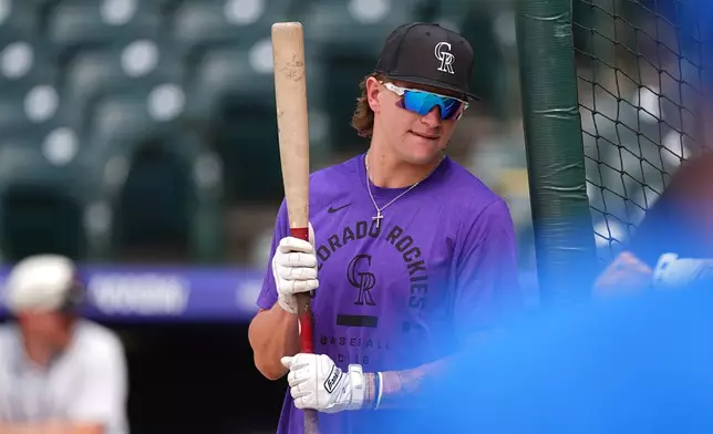 Colorado Rockies outfielder Cole Carrigg warms up before a baseball game against the Chicago Cubs Tuesday, June 9, 2026, in Denver. (AP Photo/David Zalubowski)