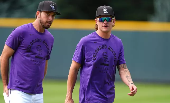 Colorado Rockies outfielder Cole Carrigg, right, who was called up from Triple A Albuquerque, warms up with outfielder Sterlin Thompson before a baseball game against the Chicago Cubs Tuesday, June 9, 2026, in Denver. (AP Photo/David Zalubowski)