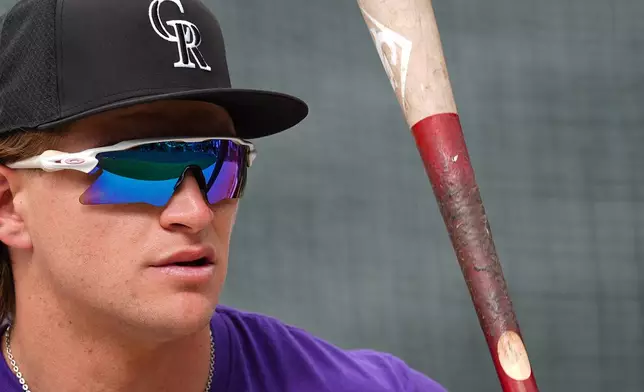 Colorado Rockies outfielder Cole Carrigg warms up before a baseball game against the Chicago Cubs, Tuesday, June 9, 2026, in Denver. (AP Photo/David Zalubowski)