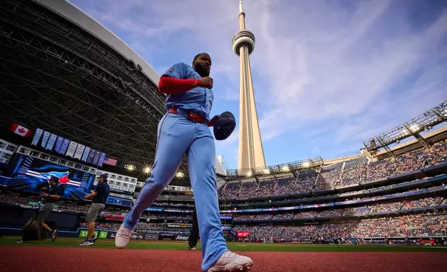 The CN Tower rises behind Toronto Blue Jays' Vladimir Guerrero Jr. as he runs before a baseball game against the Philadelphia Phillies in Toronto, Monday, June 8, 2026. (Sammy Kogan/The Canadian Press via AP)