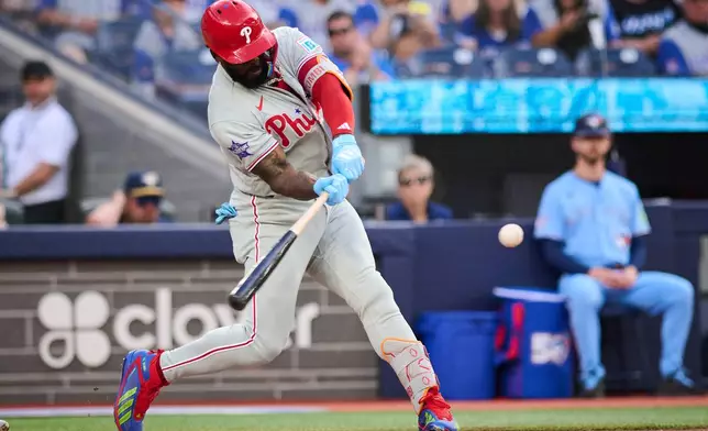 Philadelphia Phillies' Adolis Garcia hits a two-run home run against the Toronto Blue Jays during second-inning baseball game action in Toronto, Monday, June 8, 2026. (Sammy Kogan/The Canadian Press via AP)