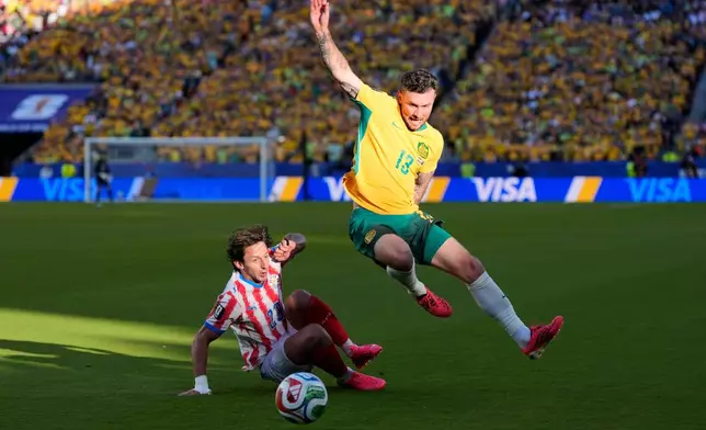 Australia's Aiden O'Neill (13) battles for the ball with Paraguay's Matias Galarza (23) during the World Cup Group D soccer match between Paraguay and Australia in Santa Clara, Calif., near San Francisco, Thursday, June 25, 2026. (AP Photo/Eugene Hoshiko)