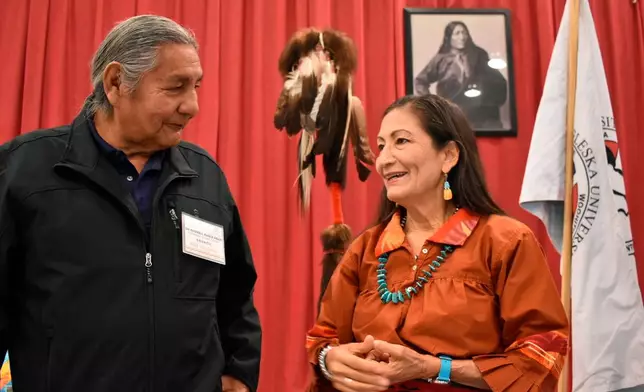 FILE - Russell Eagle Bear, left, with the Rosebud Sioux Reservation Tribal Council, talks to U.S. Interior Secretary Deb Haaland during a meeting about Native American boarding in Mission, S.D., on Oct. 15, 2022. (AP Photo/Matthew Brown, File)