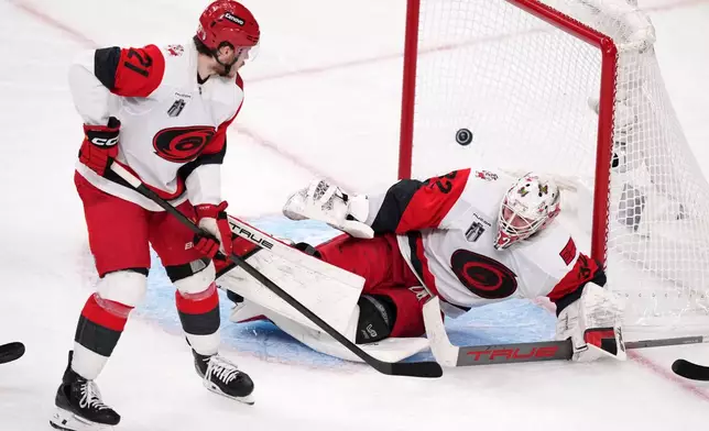 Carolina Hurricanes goaltender Brandon Bussi, right, is scored on by Carolina Hurricanes left wing Nikolaj Ehlers as defenseman Alexander Nikishin watches during the second overtime in Game 3 of the NHL hockey Stanley Cup Final series Saturday, June 6, 2026, in Las Vegas. (AP Photo/Candice Ward)