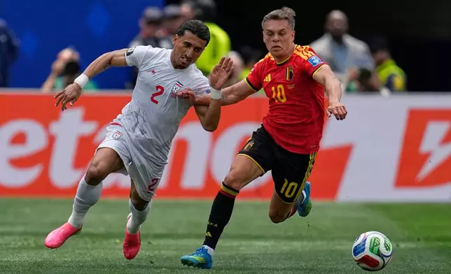 Iran's Saleh Hardani (2), left, fights for the ball with Belgium's Leandro Trossard (10) during the World Cup Group G soccer match between Belgium and Iran in Inglewood, Calif., near Los Angeles, Sunday, June 21, 2026. (AP Photo/Gregory Bull)