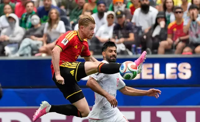 Belgium's Kevin De Bruyne, front, tries control the ball past Iran's Hossein Kanani during the World Cup Group G soccer match between Belgium and Iran in Inglewood, Calif., near Los Angeles, Sunday, June 21, 2026. (AP Photo/Andre Penner)