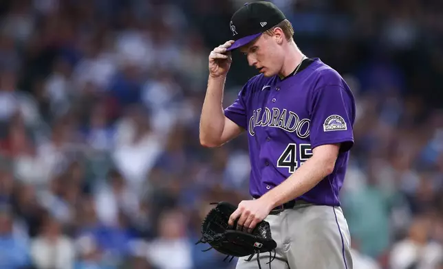 Colorado Rockies pitcher Sean Sullivan adjusts his hat while walking towards the dugout during the second inning of a baseball game against the Chicago Cubs in Chicago, Wednesday, June 17, 2026. (AP Photo/Jessie Alcheh)