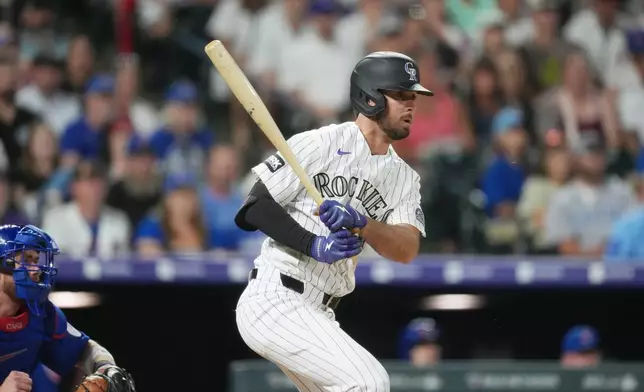 Colorado Rockies pinch-hitter Sterlin Thompson follows the flight of his walkoff, RBI single off Chicago Cubs relief pitcher Daniel Palencia in the ninth inning of a baseball game, Wednesday, June 10, 2026, in Denver. (AP Photo/David Zalubowski)