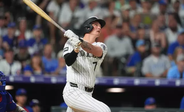 Colorado Rockies' TJ Rumfield follows the flight of his two-run home run off Chicago Cubs relief pitcher Jacob Webb in the eighth inning of a baseball game Wednesday, June 10, 2026, in Denver. (AP Photo/David Zalubowski)