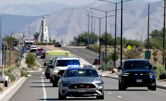 A Colorado State Patrol car leads a procession carrying the bodies of three firefighters killed while fighting the Snyder Fire in Grand Junction, Colo. Sunday, June 28, 2026. (Gretel Daugherty via AP)